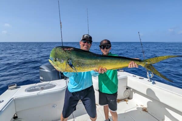 two anglers holding a big bull mahi mahi (aka dolphin or dorado) with Capt Ryan Van Fleet in the Florida Keys