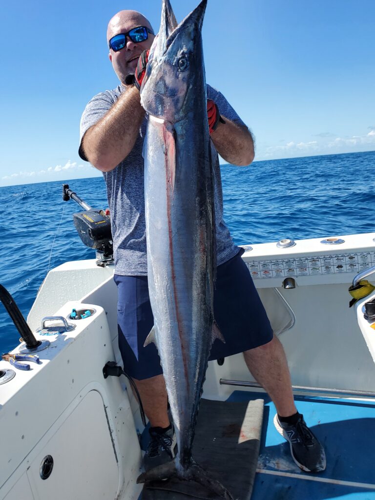 An angler holding a big wahoo