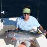 Man catching yellowfin tuna on sportfishing boat