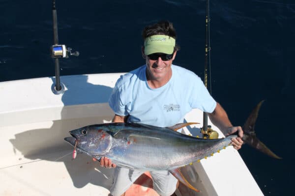 Man catching yellowfin tuna on sportfishing boat