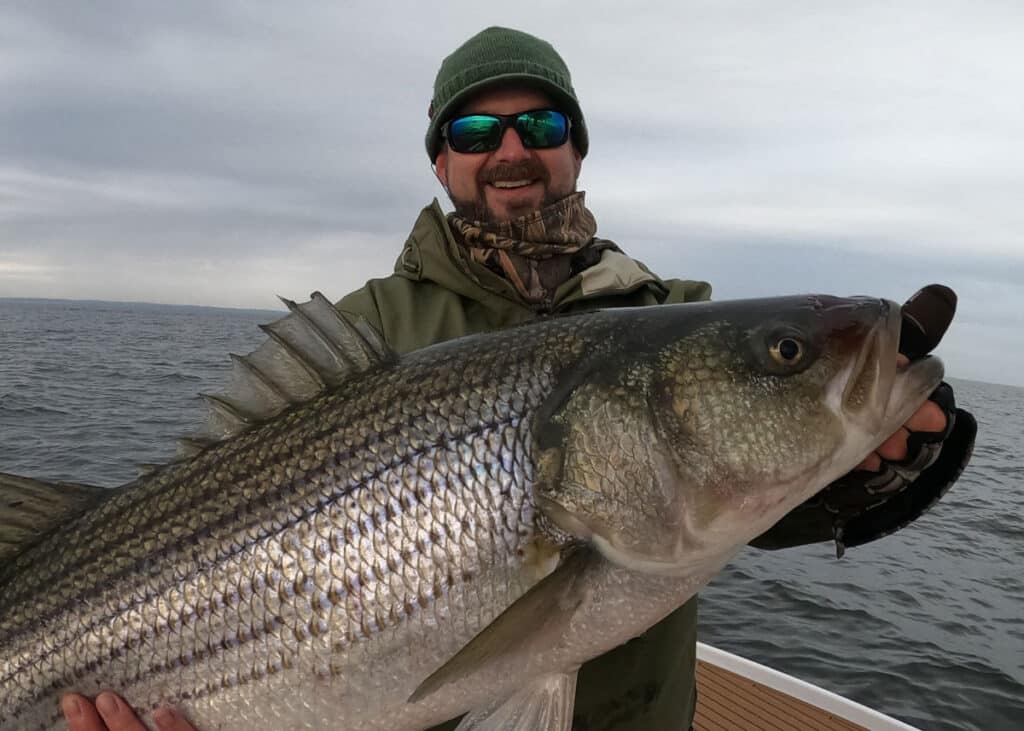 man holding large striped bass